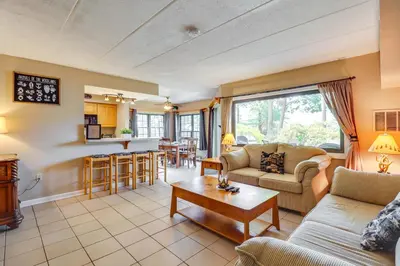a living room with a couch and a table at Steps to Shore Scenic Big Boulder Lake Condo! in Lake Harmony
