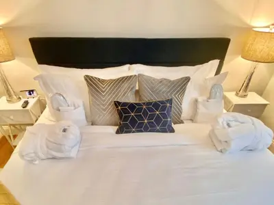 a large white bed with towels on top of it at Cedar Mill Hideaway in Woodbury