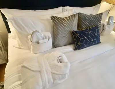 a white bed with towels and pillows on it at Cedar Mill Hideaway in Woodbury