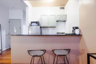 a kitchen with two chairs at a counter at Park Side Living, Get Cozy! in New York