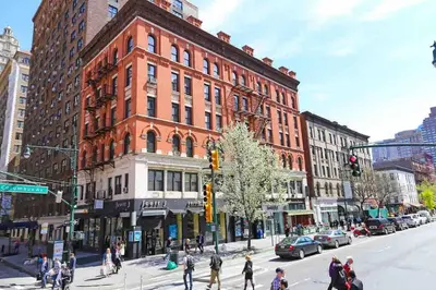 a group of people crossing a street in front of a building at Park Side Living, Get Cozy! in New York