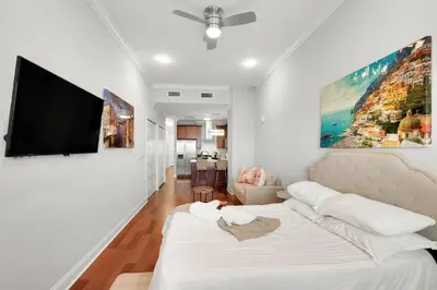 a living room with a couch and a flat screen tv at XL Studio - Studio with Pool & Scenic Rooftop in Philadelphia