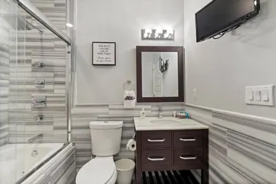 a bathroom with a toilet and a sink and a tub at XL Studio - Studio with Pool & Scenic Rooftop in Philadelphia
