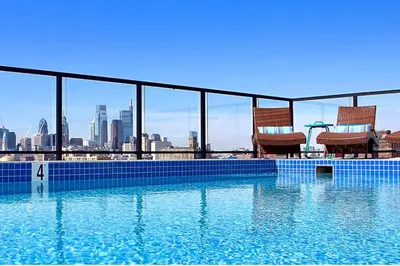 a swimming pool with two chairs on top of a building at XL Studio - Studio with Pool & Scenic Rooftop in Philadelphia