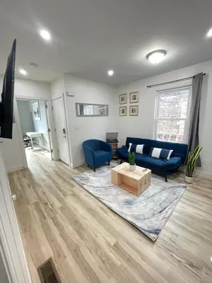 a living room with a blue couch and a table at Modern Luxury Apartment near NYC in Jersey City
