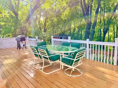 a patio with a table and chairs on a deck at Forest and River Side Tranquil House in Montague