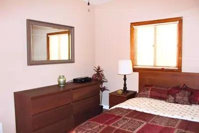 a bedroom with a bed and a dresser and a mirror at Rare River Views & Access, Cabin by Eden Islands in Montague