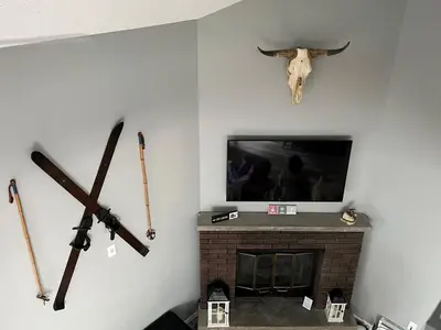 a room with a fireplace with weapons on the wall at Modern 3BR Townhouse Near Kalahari, Aquatopia & Great Wolf in Tannersville