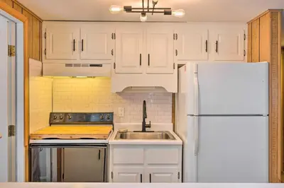 a kitchen with white cabinets and a white refrigerator at 1 Block to Lake Poconos Getaway with Fire Pit! in Pocono Lake