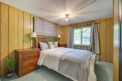 a bedroom with a large bed and a window at 1 Block to Lake Poconos Getaway with Fire Pit! in Pocono Lake