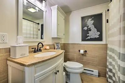 a bathroom with a toilet and a sink and a mirror at 1 Block to Lake Poconos Getaway with Fire Pit! in Pocono Lake