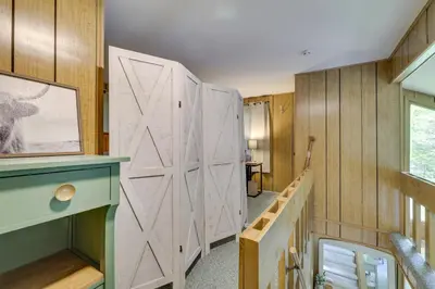 a large white barn door in a room with wooden walls at 1 Block to Lake Poconos Getaway with Fire Pit! in Pocono Lake