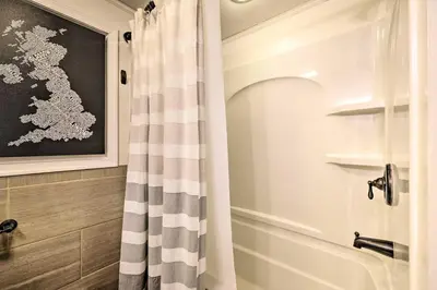 a bathroom with a shower curtain next to a bath tub at 1 Block to Lake Poconos Getaway with Fire Pit! in Pocono Lake