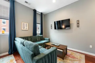 a living room with two chairs and a couch and a tv at Large 3 bdrm apt, 2ba, unique art in Philadelphia