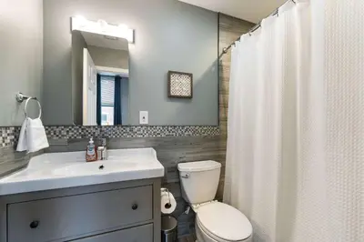 a bathroom with a sink and a toilet and a mirror at Large 3 bdrm apt, 2ba, unique art in Philadelphia