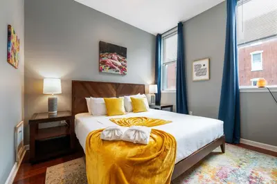 a bedroom with a bed with a yellow blanket on it at Large 3 bdrm apt, 2ba, unique art in Philadelphia