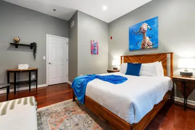 a bedroom with a large bed with a blue blanket at Large 3 bdrm apt, 2ba, unique art in Philadelphia
