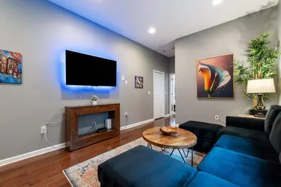 a living room with a blue couch and a tv at Large 3 bdrm apt, 2ba, unique art in Philadelphia