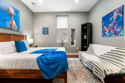 a bedroom with a bed with a blue blanket on it at Large 3 bdrm apt, 2ba, unique art in Philadelphia
