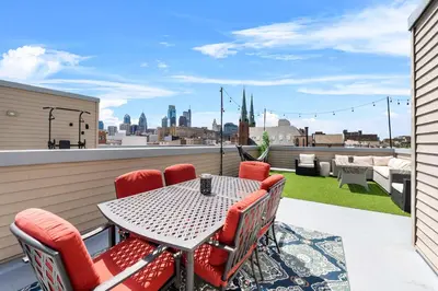 a patio with a table and chairs on a balcony at Brand New Dbl Unit Roofdeck Outdoor Patio in Philadelphia