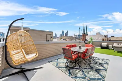 a patio with chairs and a table on a roof at Brand New Dbl Unit Roofdeck Outdoor Patio in Philadelphia
