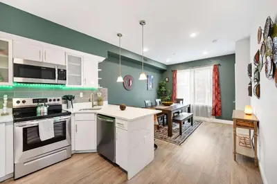 a kitchen with white appliances and a dining room at Brand New Dbl Unit Roofdeck Outdoor Patio in Philadelphia