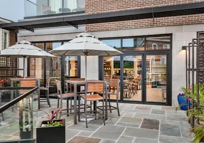 a patio with a table with chairs and umbrellas at Hyatt Place Newark-Main Street in Newark