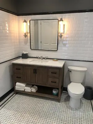 a bathroom with a toilet and a sink with a mirror at Hyatt Place Newark-Main Street in Newark