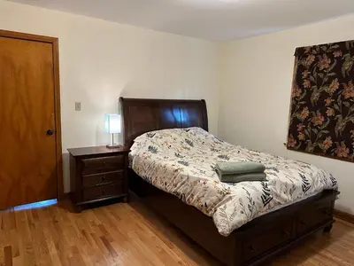 a bedroom with a bed and a night stand with a lamp at M2 Comfortable Room near Rutgers U, hospitals in New Brunswick