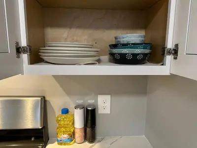 a kitchen cabinet with plates and bowls in it at M2 Comfortable Room near Rutgers U, hospitals in New Brunswick