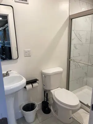 a bathroom with a toilet and a sink and a shower at KAMA CENTRAL PARK in New York