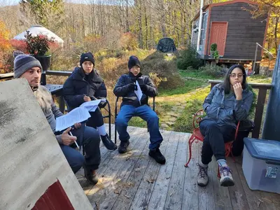 a group of people sitting on a porch at Catskills tiny house cabin in Livingston Manor