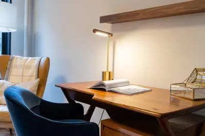 a desk with a book and a lamp and a chair at E10-3 3BR Designer Townhouse in New York
