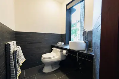 a bathroom with a toilet and a sink and a window at E10-3 3BR Designer Townhouse in New York