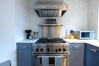 a kitchen with blue cabinets and a stove top oven at E10-3 3BR Designer Townhouse in New York