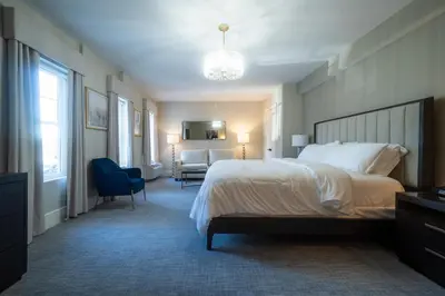a hotel room with a large bed and a chair at Orange Inn Boutique Hotel in Goshen