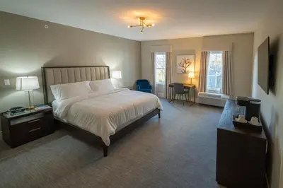 a bedroom with a large bed and two windows at Orange Inn Boutique Hotel in Goshen