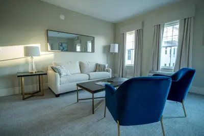 a living room with a couch and a table and chairs at Orange Inn Boutique Hotel in Goshen