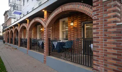 a brick building with an iron fence and windows at Orange Inn Boutique Hotel in Goshen