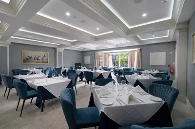 a dining room with tables and chairs and ceilings at Orange Inn Boutique Hotel in Goshen