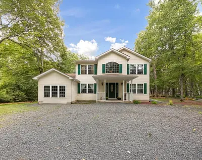 a large white house with a driveway at Spacious Home by Kalahari Waterpark, Camelback, Jim Thorpe, FREE EV and PRIVATE SAUNA in Albrightsville