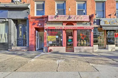 a store on a street in a city at Hoboken Condo Walk to Public Transit! in Hoboken