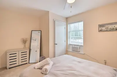 a bedroom with a white bed and a mirror at Gas Grill, Lake Access Scenic Poconos Retreat! in East Stroudsburg