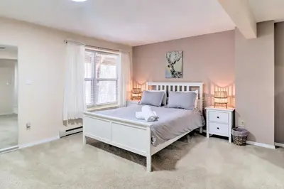a bedroom with a white bed and a window at Gas Grill, Lake Access Scenic Poconos Retreat! in East Stroudsburg
