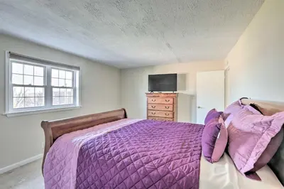 a bedroom with a purple bed and a tv at Cozy Townhome about 12 Mi to Downtown Philly!
