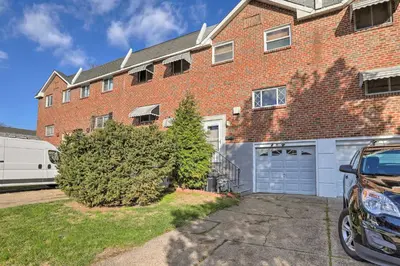 a brick apartment building with a garage at Cozy Townhome about 12 Mi to Downtown Philly!
