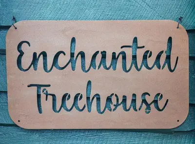 a sign that reads enchanted thrifty hanging on a wall at Lake View Enchanted Treehouse- Lake Harmony in Lake Harmony