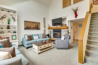a living room with blue furniture and a fireplace at Game Room and BBQ Waterfront Lake Harmony Condo! in Lake Harmony