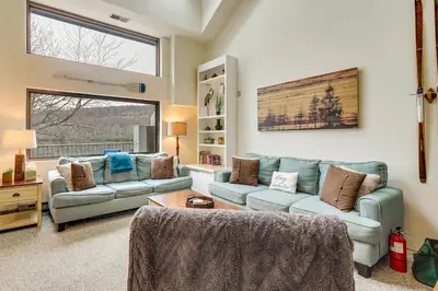a living room with two couches and a table at Game Room and BBQ Waterfront Lake Harmony Condo! in Lake Harmony