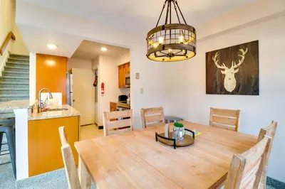 a dining room and kitchen with a wooden table at Game Room and BBQ Waterfront Lake Harmony Condo! in Lake Harmony